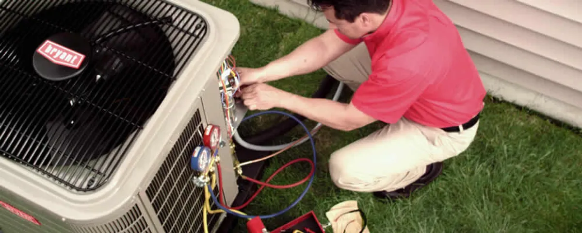 HVAC technician servicing an outdoor air conditioner unit in Greenville, NC
